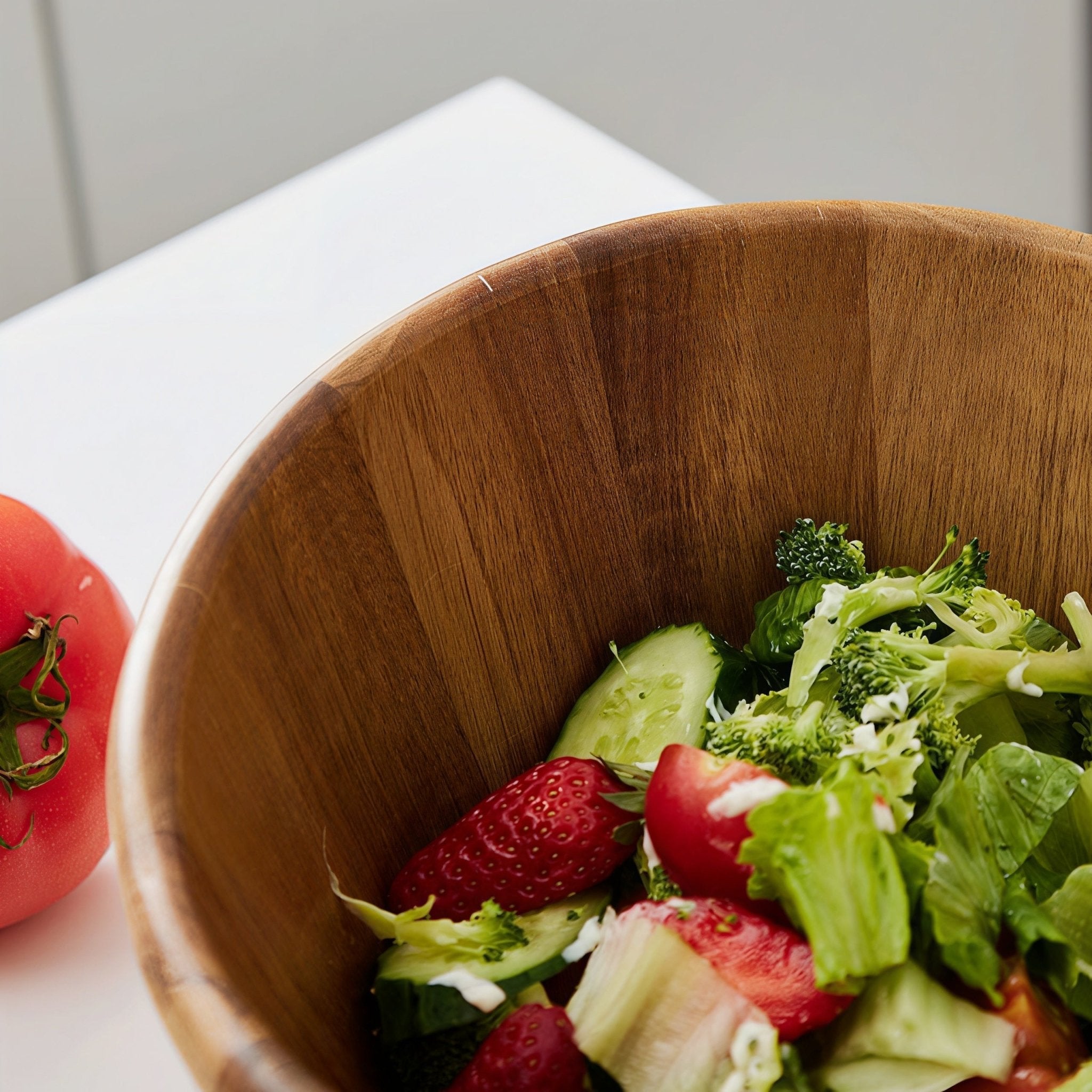 Close-up of Oakory acacia wave salad bowl filled with fresh salad, showing smooth wood interior