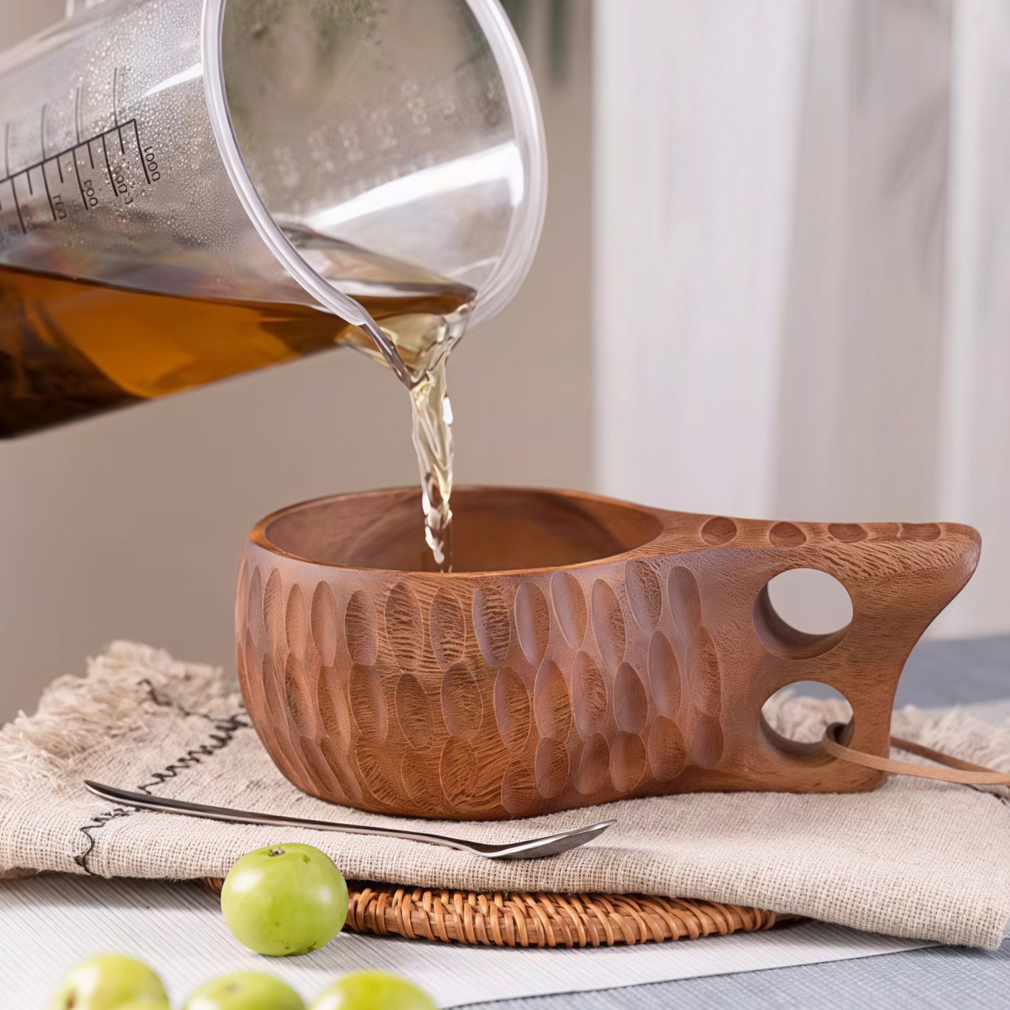 Oakory hammered wooden mug being filled with herbal tea, rustic table setting